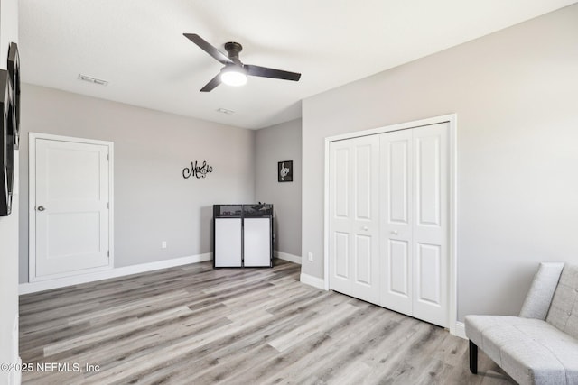 unfurnished room featuring a ceiling fan, light wood-type flooring, visible vents, and baseboards