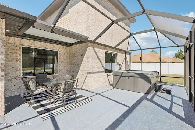 view of patio / terrace with outdoor dining space, glass enclosure, fence, and a hot tub