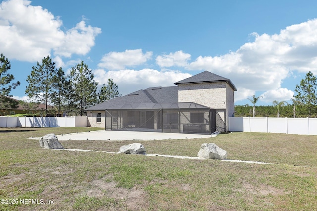 rear view of property with glass enclosure, a fenced backyard, and a lawn