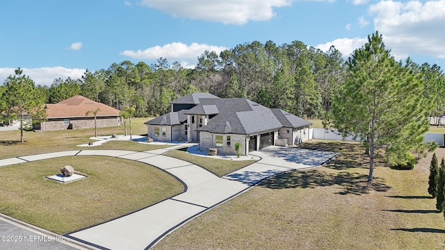 view of front of house with an attached garage, stone siding, concrete driveway, and a front yard