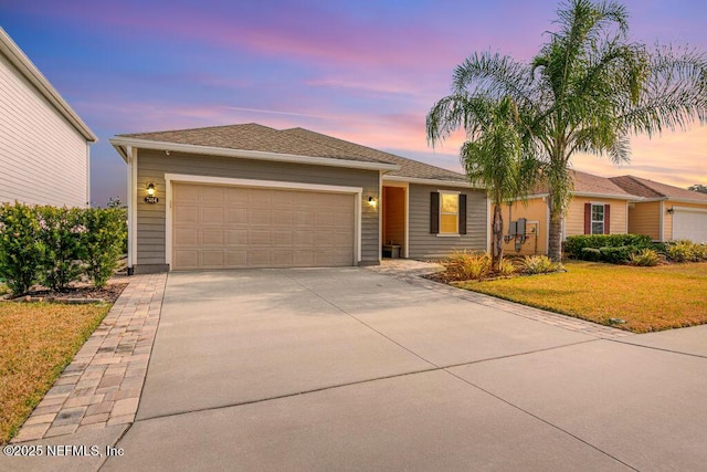 view of front facade with a garage and a yard