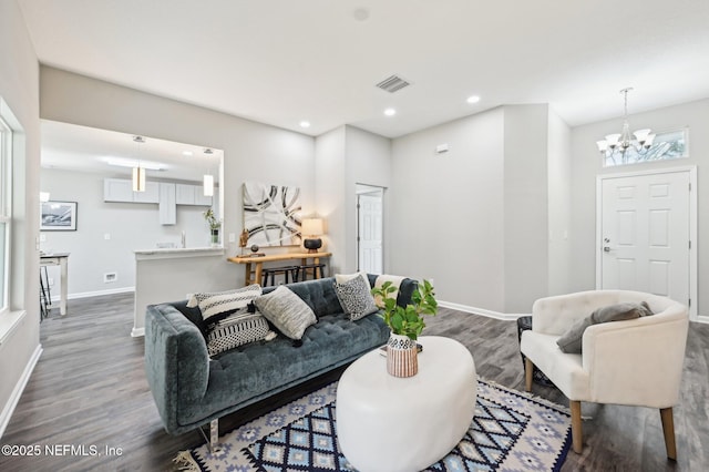 living room with dark hardwood / wood-style floors and a chandelier