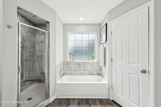 bathroom with independent shower and bath and hardwood / wood-style floors