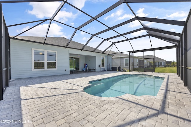 view of swimming pool with glass enclosure and a patio area