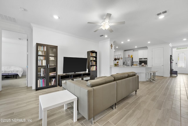 living room with crown molding and ceiling fan