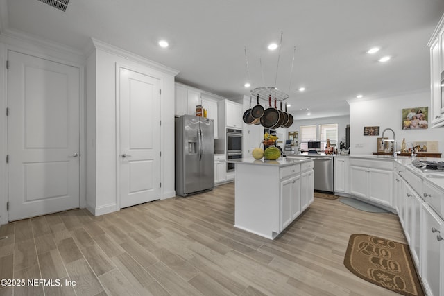 kitchen with sink, light hardwood / wood-style flooring, appliances with stainless steel finishes, white cabinetry, and kitchen peninsula