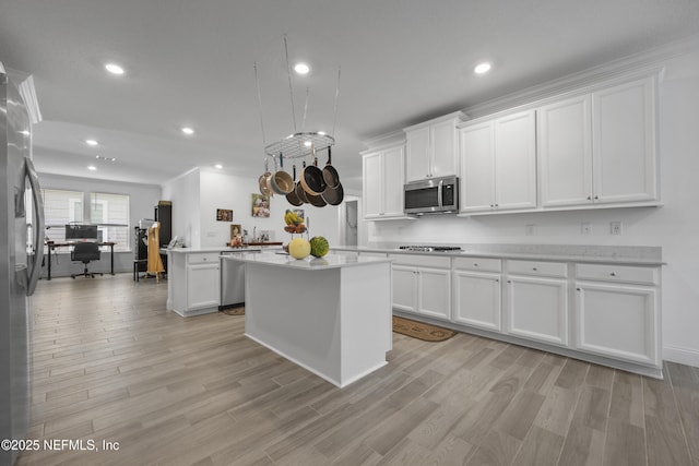 kitchen featuring white cabinetry, light hardwood / wood-style flooring, a center island, and appliances with stainless steel finishes