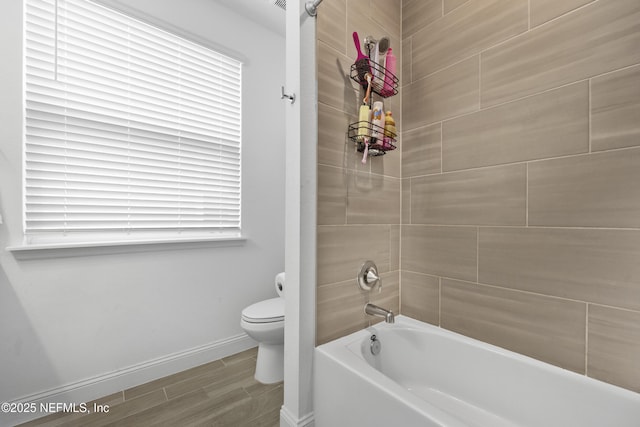 bathroom featuring tiled shower / bath, toilet, and hardwood / wood-style floors