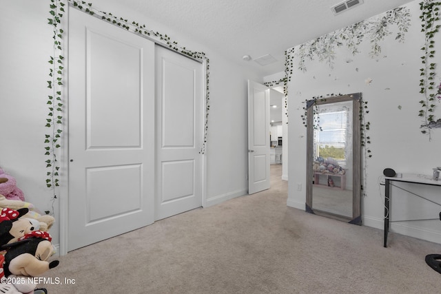 unfurnished bedroom featuring light carpet and a textured ceiling