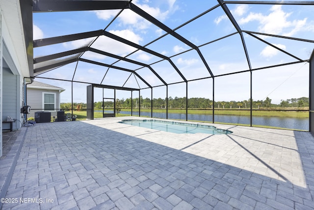 view of pool with a lanai, a patio area, and a water view