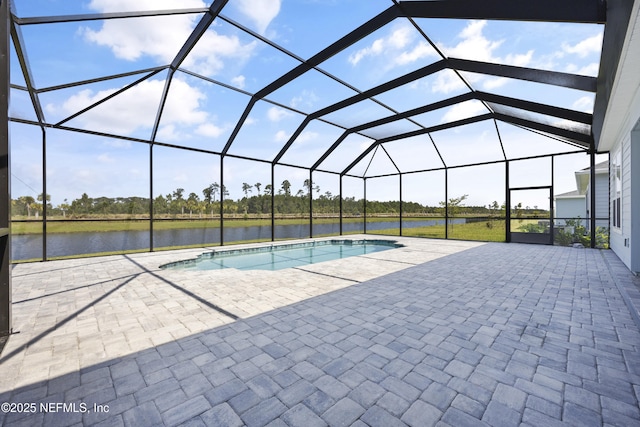 view of swimming pool featuring a patio, a water view, and glass enclosure