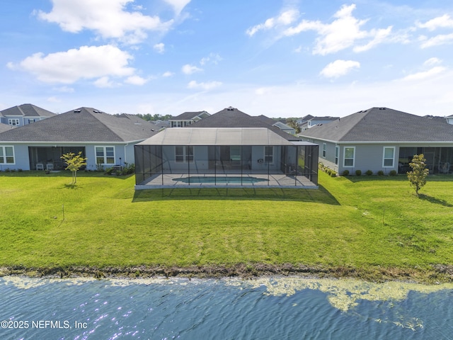 back of house featuring a water view, glass enclosure, and a lawn