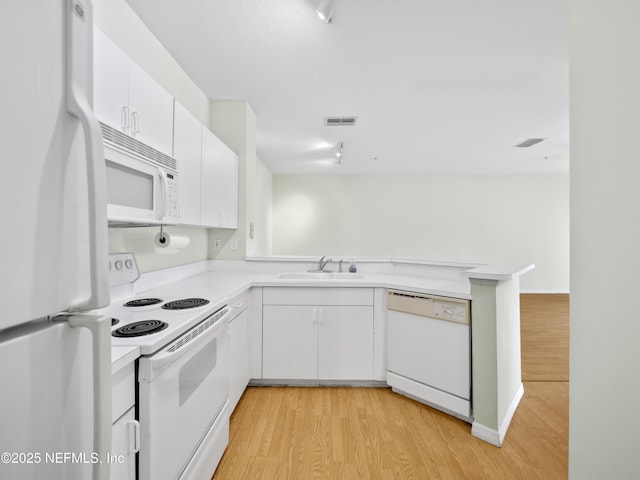 kitchen with sink, white cabinets, white appliances, and kitchen peninsula