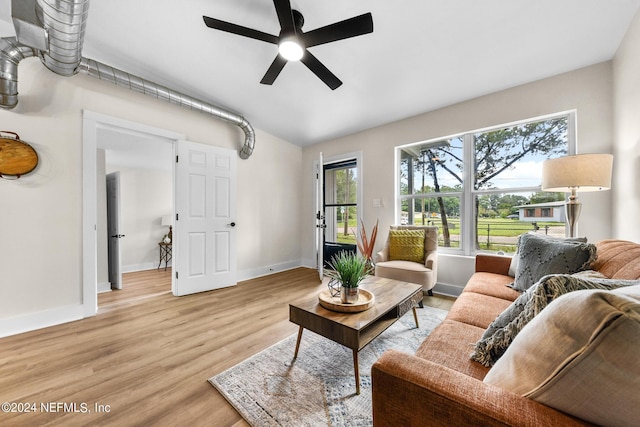 living room with ceiling fan, lofted ceiling, and light hardwood / wood-style floors