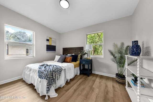 bedroom featuring hardwood / wood-style flooring and lofted ceiling