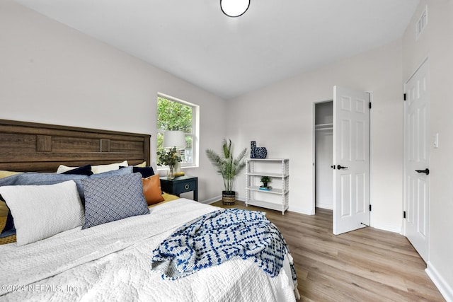 bedroom with hardwood / wood-style flooring and lofted ceiling