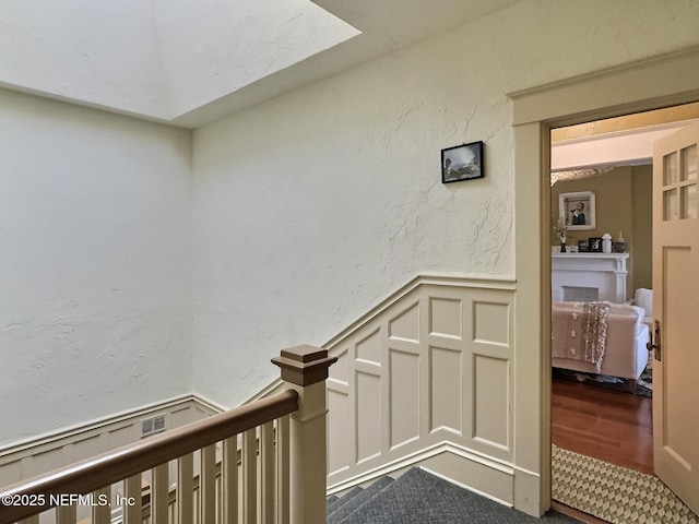 corridor featuring hardwood / wood-style flooring and a skylight