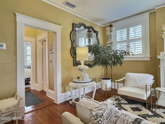 sitting room with hardwood / wood-style flooring and crown molding