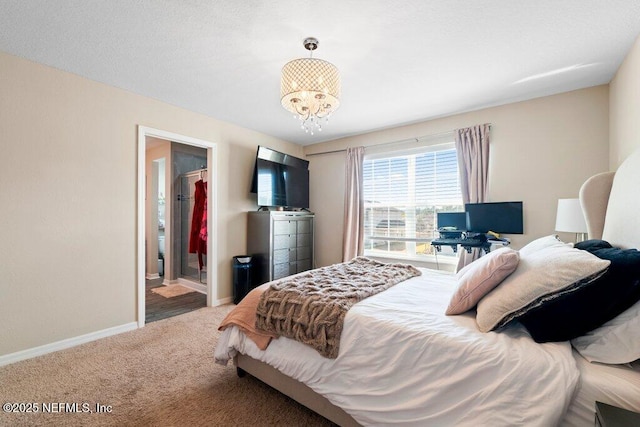 carpeted bedroom featuring a notable chandelier and ensuite bath