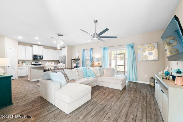 living room with hardwood / wood-style flooring and ceiling fan