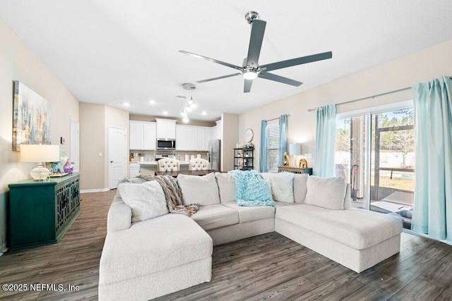 living room featuring dark wood-type flooring and ceiling fan