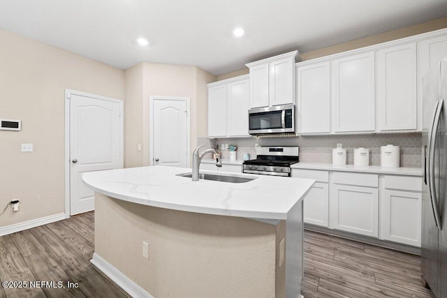 kitchen with sink, a center island with sink, white cabinets, and appliances with stainless steel finishes