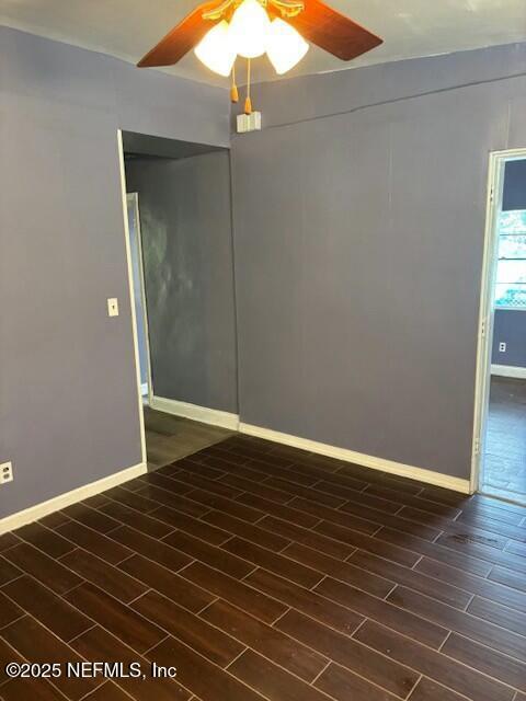 unfurnished room featuring a ceiling fan, wood tiled floor, and baseboards