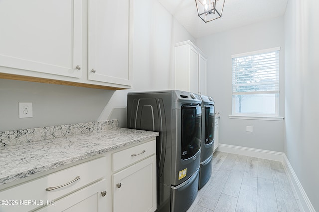 1351 Weaver Glen Rd, Jacksonville, FL 32223 - laundry area featuring light wood-type flooring, cabinet space, washer and clothes dryer, and baseboards