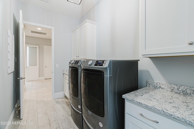 1351 Weaver Glen Rd, Jacksonville, FL 32223 - clothes washing area featuring cabinet space, light wood finished floors, baseboards, a textured ceiling, and washer and dryer