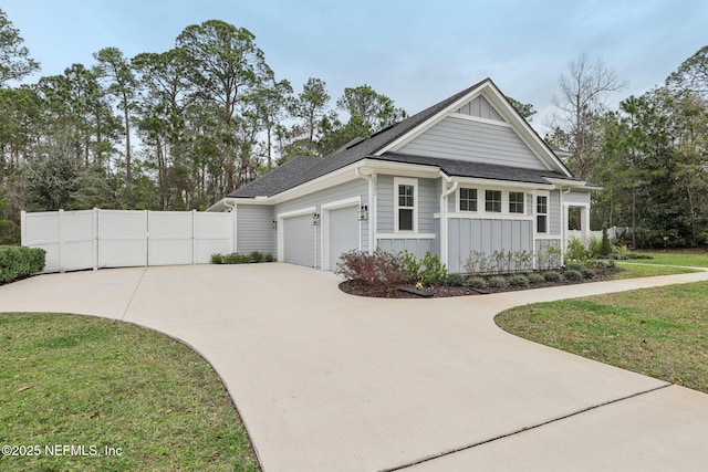 1351 Weaver Glen Rd, Jacksonville, FL 32223 - view of side of property with board and batten siding, concrete driveway, fence, and an attached garage
