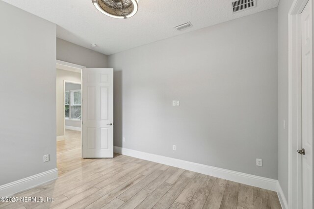 1351 Weaver Glen Rd, Jacksonville, FL 32223 - unfurnished bedroom featuring baseboards, visible vents, a textured ceiling, and light wood finished floors