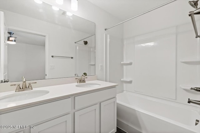 bathroom featuring washtub / shower combination and vanity