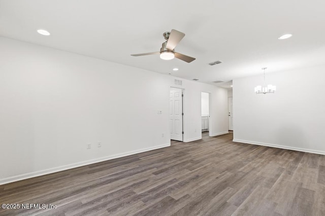 empty room featuring dark wood-type flooring and ceiling fan with notable chandelier