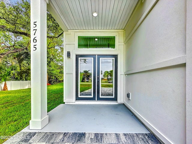 doorway to property featuring french doors and a lawn