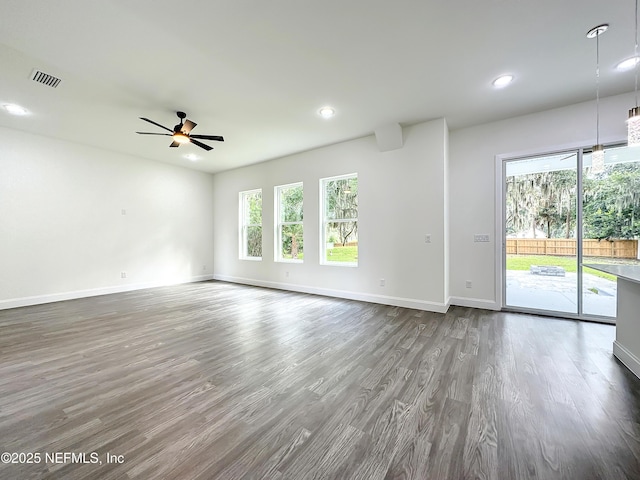 empty room with hardwood / wood-style floors, a wealth of natural light, and ceiling fan