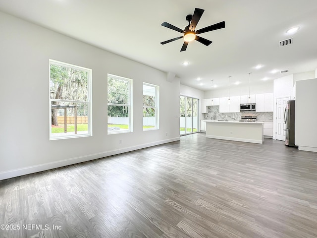 unfurnished living room with ceiling fan and light wood-type flooring