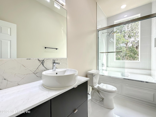 full bathroom with vanity, toilet, and combined bath / shower with glass door