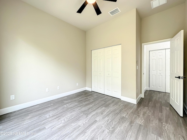 unfurnished bedroom featuring wood-type flooring, a closet, and ceiling fan