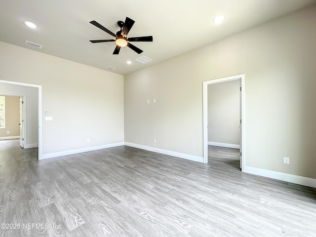 spare room with ceiling fan and light wood-type flooring