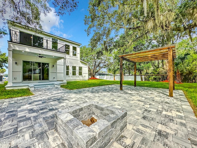 rear view of property with a pergola, a fire pit, a patio area, and a balcony