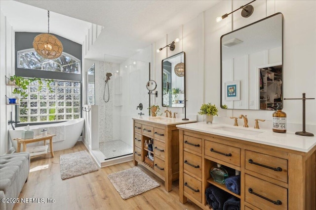 bathroom featuring vanity, hardwood / wood-style floors, and separate shower and tub