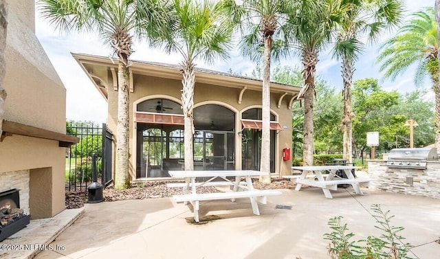 12700 Bartram Park Blvd Unit 2333, Jacksonville, FL 32258 - view of patio with an outdoor stone fireplace, area for grilling, a ceiling fan, outdoor dining space, and exterior kitchen