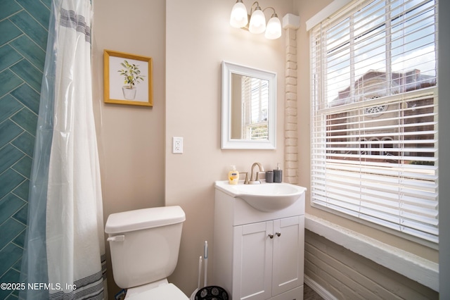 bathroom with toilet, vanity, and a shower with curtain