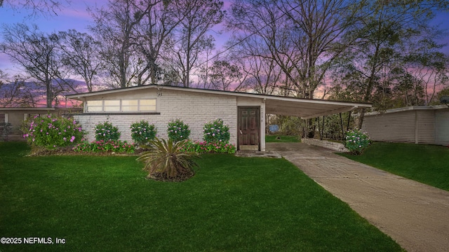 view of front of property with a lawn and a carport