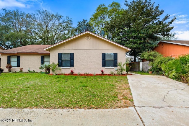 ranch-style house featuring a front yard, fence, and stucco siding