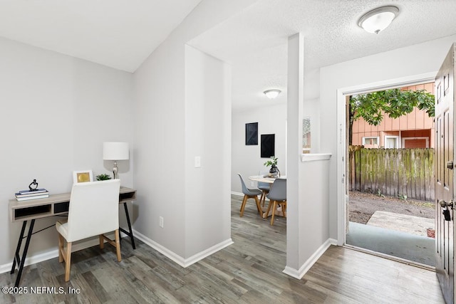 office featuring a textured ceiling, baseboards, and wood finished floors