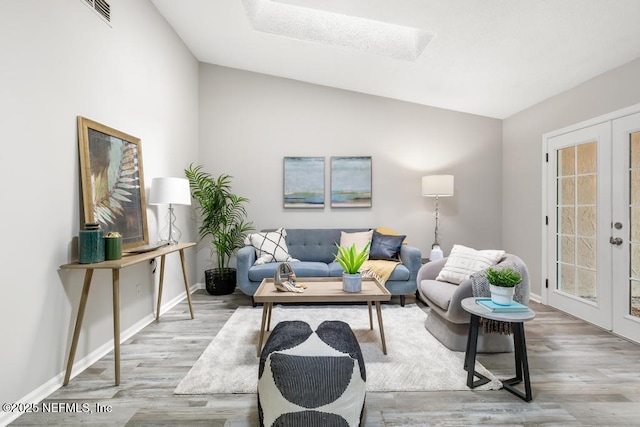 living room with french doors, wood finished floors, visible vents, and baseboards