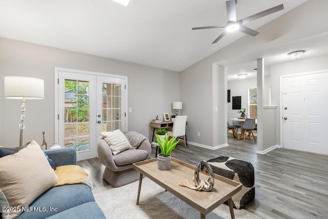 living room with lofted ceiling, french doors, a healthy amount of sunlight, and wood finished floors