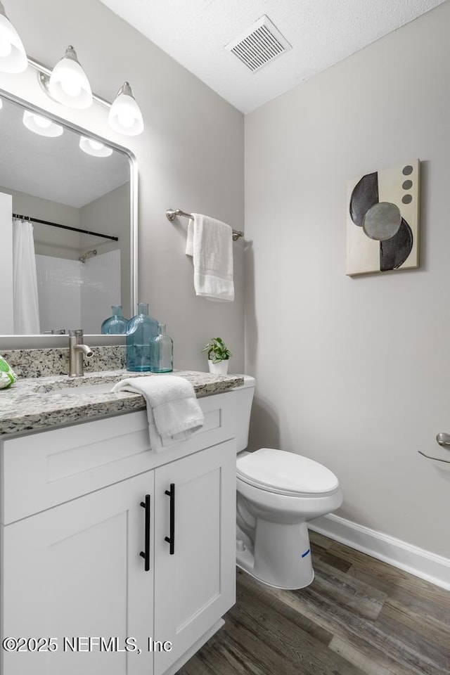 full bath featuring visible vents, toilet, a shower with curtain, wood finished floors, and vanity