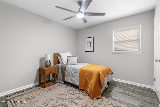 bedroom featuring ceiling fan, wood finished floors, and baseboards